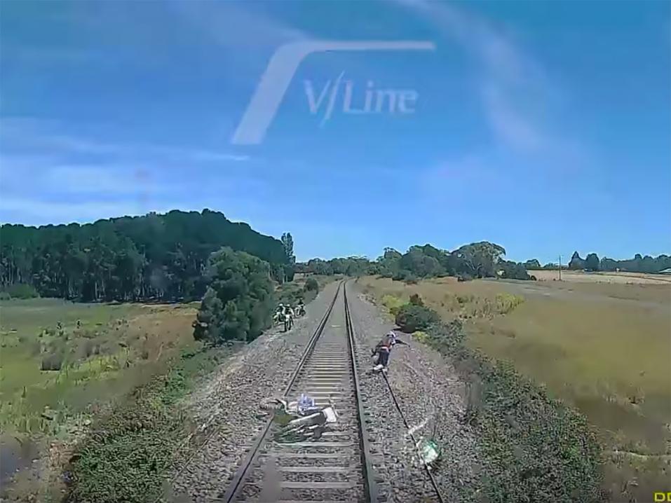 Tiukka tilanne, jossa motoristi yrittää pelastautua lähestyvän junan alta loikkaamalla.
