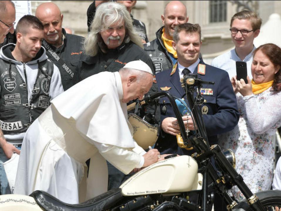 Paavi signeeraamassa hyväntekeväisyyteen huutokaupattavaa kustomoitua Harley-Davidsonia.
