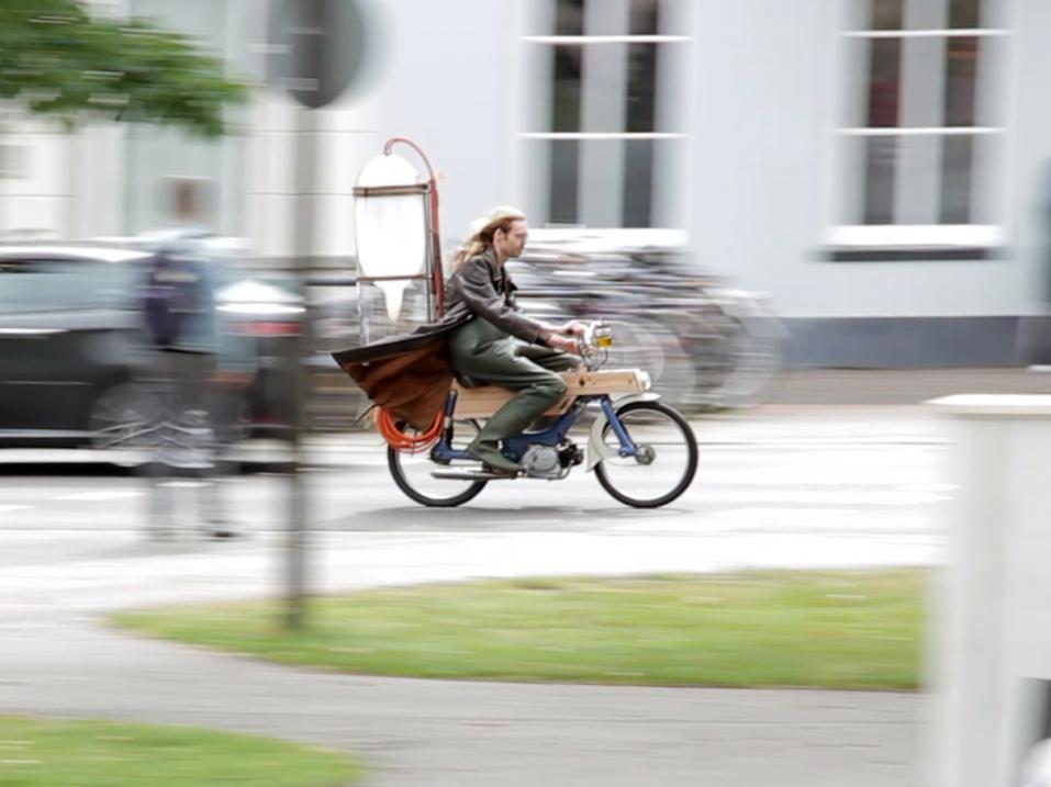 Gijs Schalkx ajamassa 'Schlootmotorillaan'. Kyse on metaanikäyttöiseksi muutetusta mopedista, johon Gijs kerää metaanin lähimmästä lammesta.