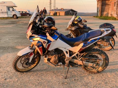 Honda Africa Twin klo 00.04 noin ja keskiyön aurinko Kaunispään huipulla.