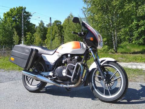 Moro. Tässä kesäpäivän työmatka-ajoneuvoni, vaimon ja minun -83 Suzuki GS 450. Täydellinen pyörä, joskin jotkin sähkö- ym. osat kyllä kaipaisivat kunnostusta tai vaihtoa. Takavalona pitää olla polkupyöränledi, kun valokatkaisijassa on häiriöitä. Tähän aikaan vuodesta tosin takavaloa vain vähän tarvitsee. Yst.terv. Mika