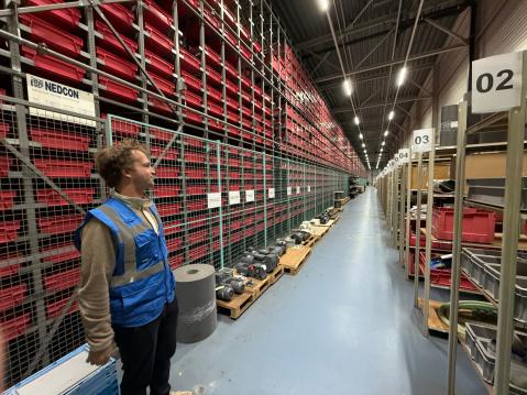 Korkeasta automaatioasteesta huolimatta käsityön määrä varastossa on suuri. Kuvassa oppaamme kierroksella.