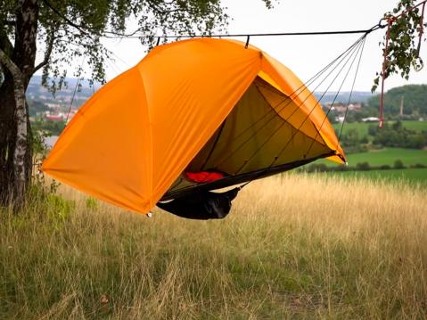 HoverTent ripustettuna puiden varaan sivuistaan. Paracord-naruverkolla teltta saadaan asetettua vaakasuoraan.