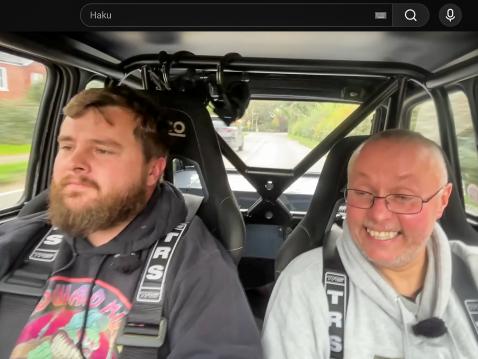 Tom ratissa (kuvassa vasemmalla) ja Twin Engine Corsa -nimimerkkiä käyttävä tubettaja pelkääjän paikalla.