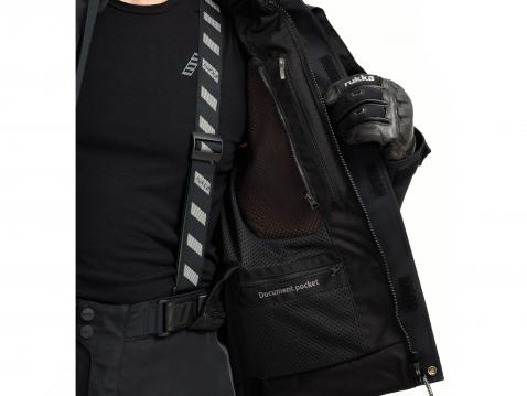 Suoja paikallaan puvun rintataskussa.