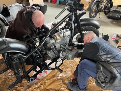 Ukrainalaisia moottoripyöräkerholaisia korjaamassa ajoneuvoja.