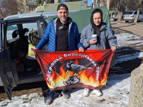 Ukrainalaisia moottoripyöräkerholaisia jakamassa avustuksia.