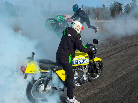 Artsi näyttää Möhköllä kuminpolttamisen mallia. Taustalla Niko Säkkinen.
