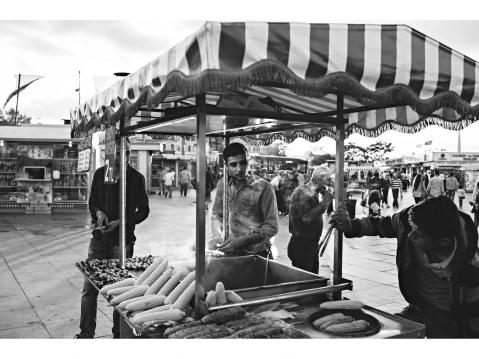 Istambul – TURKEY. 2 June 2015 A man stands in his push-car where he sells freshly boiled or grilled corn on the cob, often sprinkled with salt or spices.