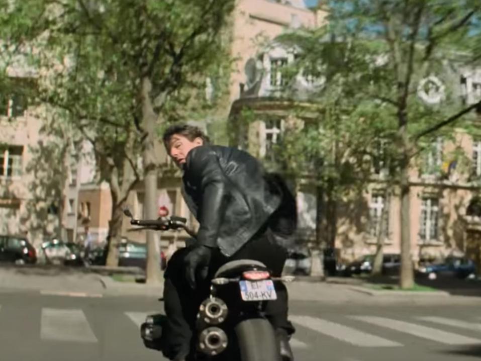 Tom Cruise Mission: Impossible - Fallout. Sekunnin kymmenesosan jälkeen Cruise aka Ethan Hunt törmää sivulta tulevaan autoon ja lentää yli sen konepellin. Kuva edellisestä Mission Impossiblesta.