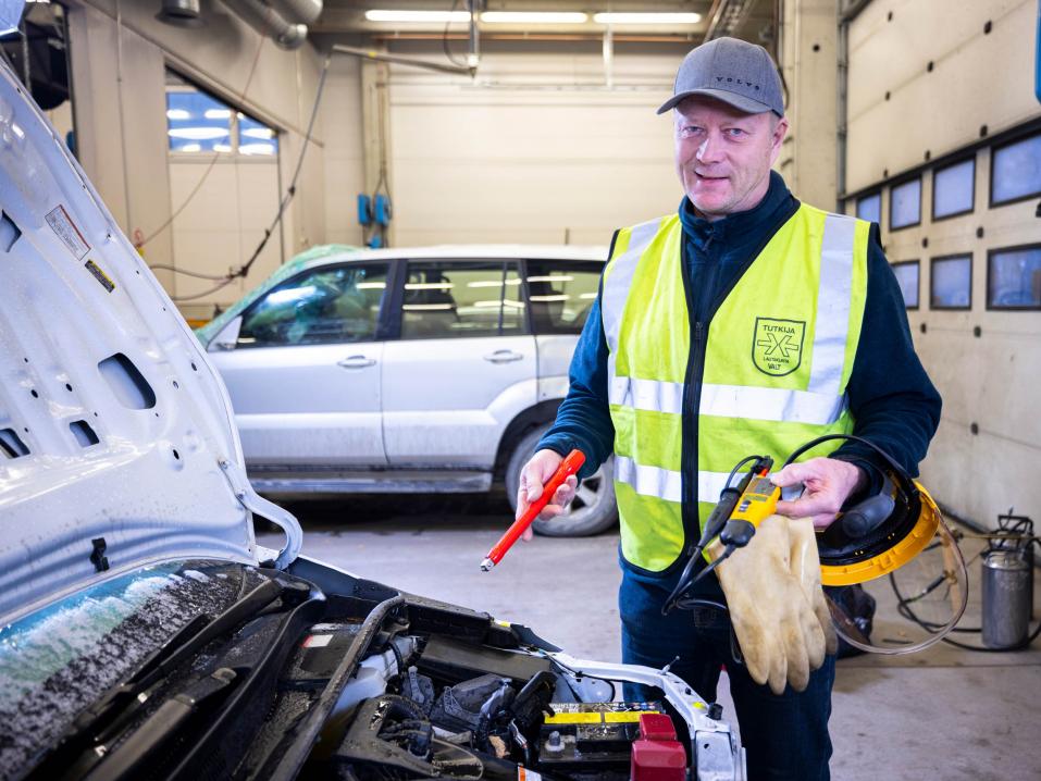 Tapio Kyngäs tutkii onnettomuusautoa Copartilla, mistä löytyy myös laite ajoneuvodatan lukemiseen. Sen avulla selviää muun muassa ajoneuvon nopeus onnettomuushetkellä sekä tiedot kuljettajan tekemistä ohjausliikkeistä ja jarrutuksesta. Kuva: Sami Peltoniemi.