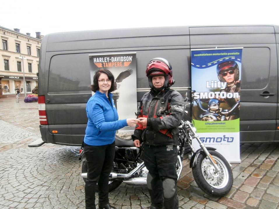 SMOTOn puheenjohtaja Marja Kuosmanen luovutti pyörän avaimet onnelliselle voittajalle viime kesän Mp-arvonnan jälkeen.
