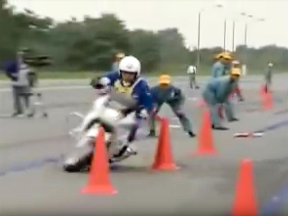 Japanilainen moottoripyöräpoliisin alku radalla loppukokeessa. Kullakin osuudella tarkkaillaan useamman mittamiehen voimin, ettei kokelas tee virheitä.