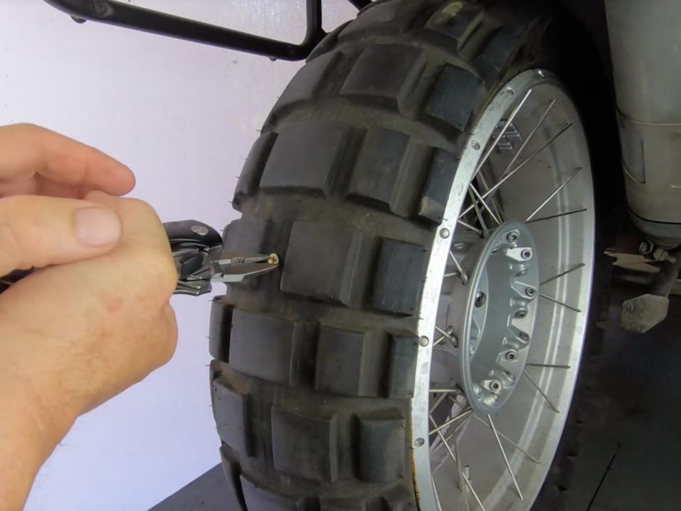 MotoPressorin linkkarityökalussa on pihdit, joilla voi poistaa renkaan rikkoneen esineen.