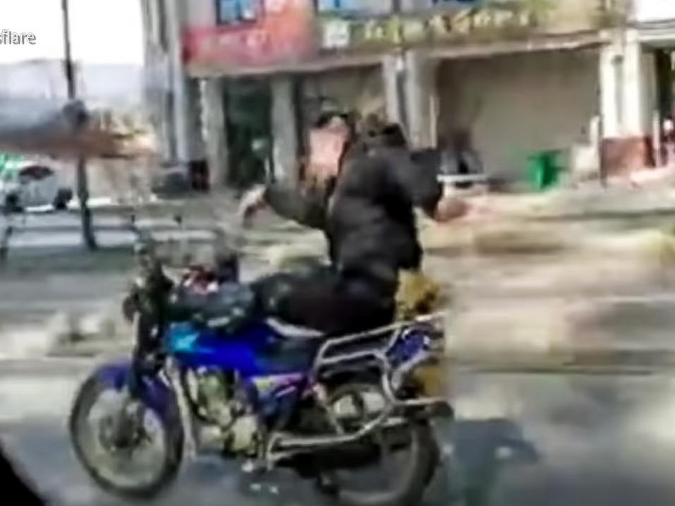 Kiinalaismies ohjasi moottoripyörää jaloillaan ja tanssi käsillään ajaessaan. Paikallinen poliisi pilasi ilon.