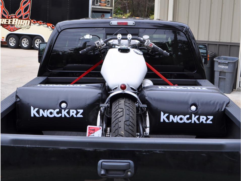 Moottoripyörä tuettuna avopakettiauton kyytiin kahdella Knockrzilla.