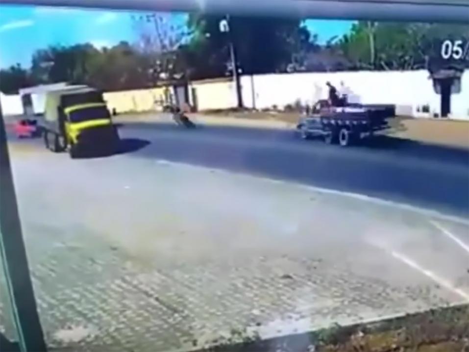 Musta laikku keltaisen kuorma-auton ja oikealta tulevan kuorma-auton välillä on pahassa tilanteessa oleva moottoripyöräilijä.
