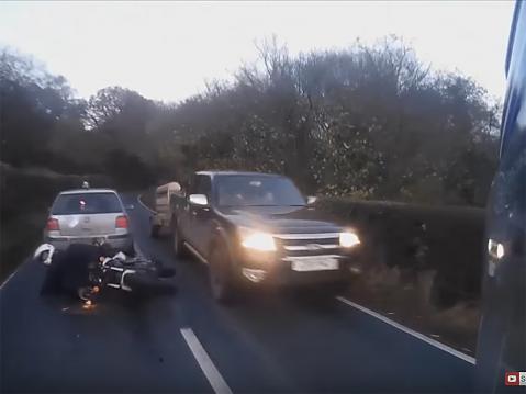 Jarrutuksesta huolimatta moottoripyöräilijä törmää auton perään ja kaatuu. Onneksi hän ei ajaudu kohdalla olevan auton alle.
