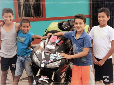 Nuoria miehiä Nicaraguassa ihailemassa Nikki Misurellin pyörää.