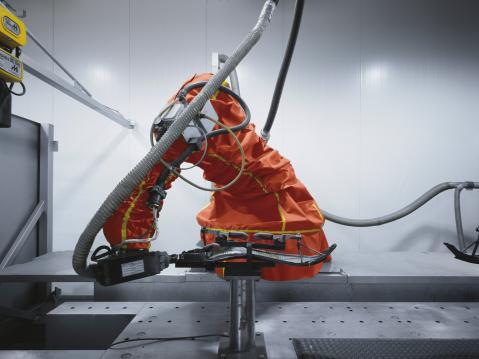 Komposiittiputkistoja leikkaava robotti Akrapovicin tuotantolaitoksilla.